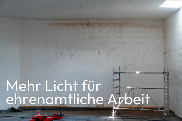 Raum während der Renovierung mit fahrbarem Gerüst und Werkzeug. Eingeblendeter Schriftzug: „Mehr Licht für ehrenamtliche Arbeit“.